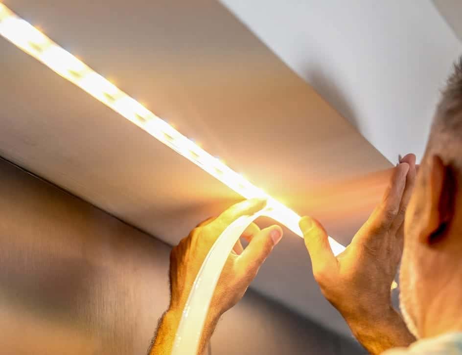 man putting up LED lights